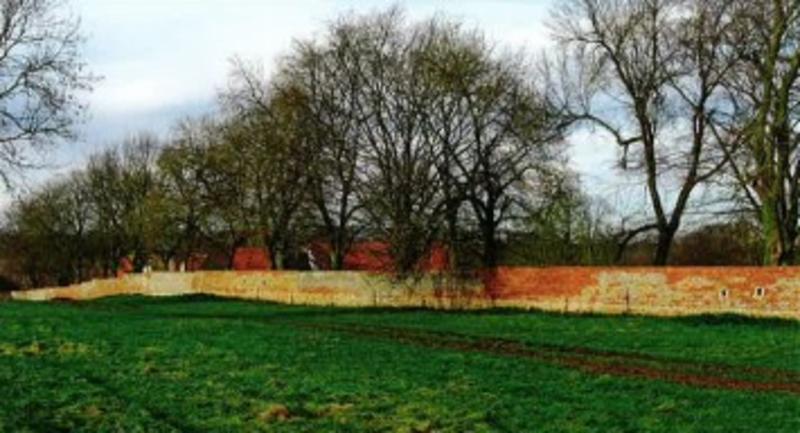  Restored garden wall from the south-east - the visible holes were cut to give the  defenders a better field of fire (Martin Drury) 