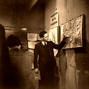 A man pointing at a weather map on the wall