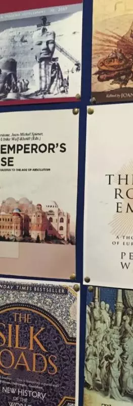 Historical book covers on display on a wall